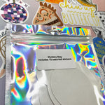 The back of the Fun Mystery Sticker Bag on a pink background with stickers surrounding it.