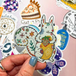One of the mystery stickers being held in front of other stickers.