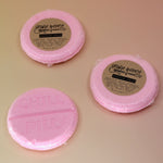 Three Chill Pill Bubble Bath Bombs on a peach colored background.