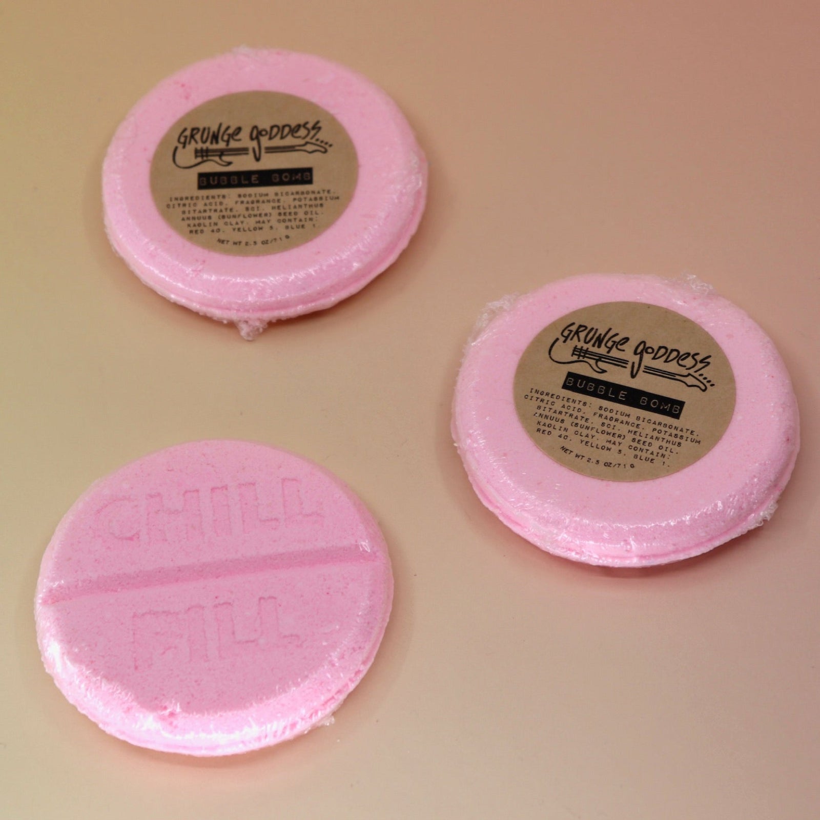 Three Chill Pill Bubble Bath Bombs on a peach colored background.