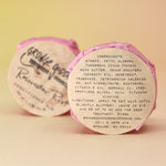 Two of the Rosewater Riot - Conditioner Bars, one showing off the back of the packaging, all on a peach-colored background.
