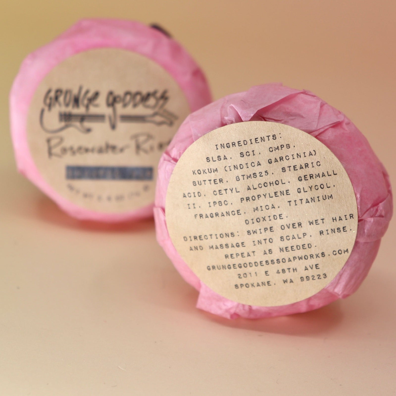 Two Rosewater Riot - Shampoo Bars, one showing the back of the packaging all on a peach-colored background.