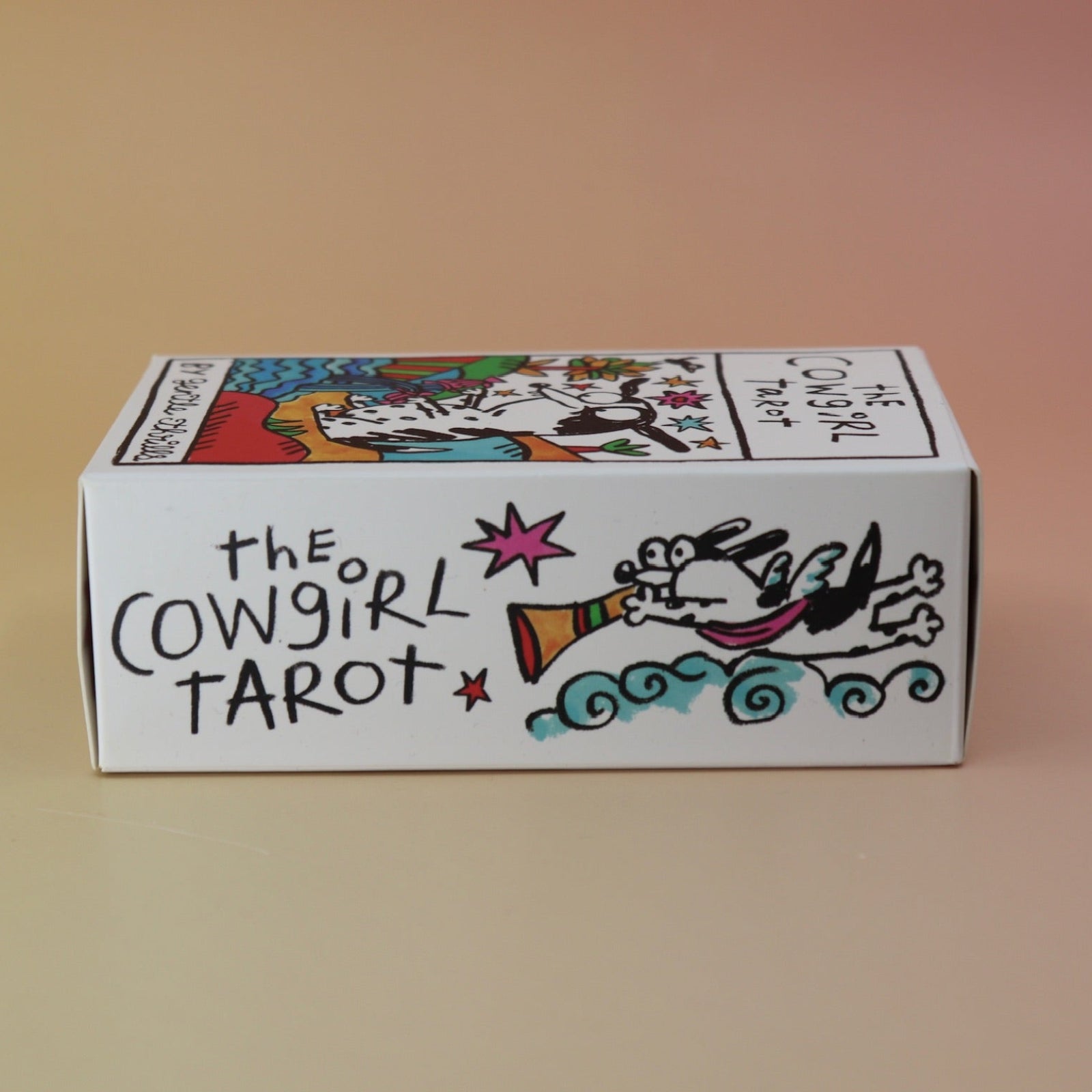 The side of the Cowgirl Tarot Deck on a pink and yellow background.