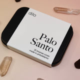 The Palo Santo Incense Cones container surrounded by crystals and incense cones.
