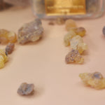 An up close image of the frankincense pieces on a light pink background.