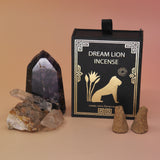 The The Wish Granter Incense Cones box next to two crystal pieces with incense cones in front of it all on a pink and yellow background.