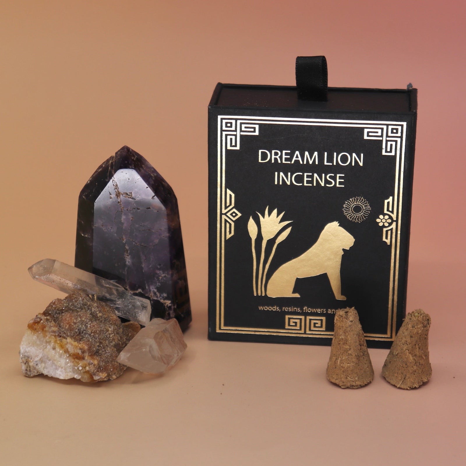 The The Wish Granter Incense Cones box next to two crystal pieces with incense cones in front of it all on a pink and yellow background.