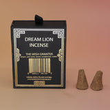 The back of the Wish Granter Incense Cones box next to two incense cones on a pink and yellow background.