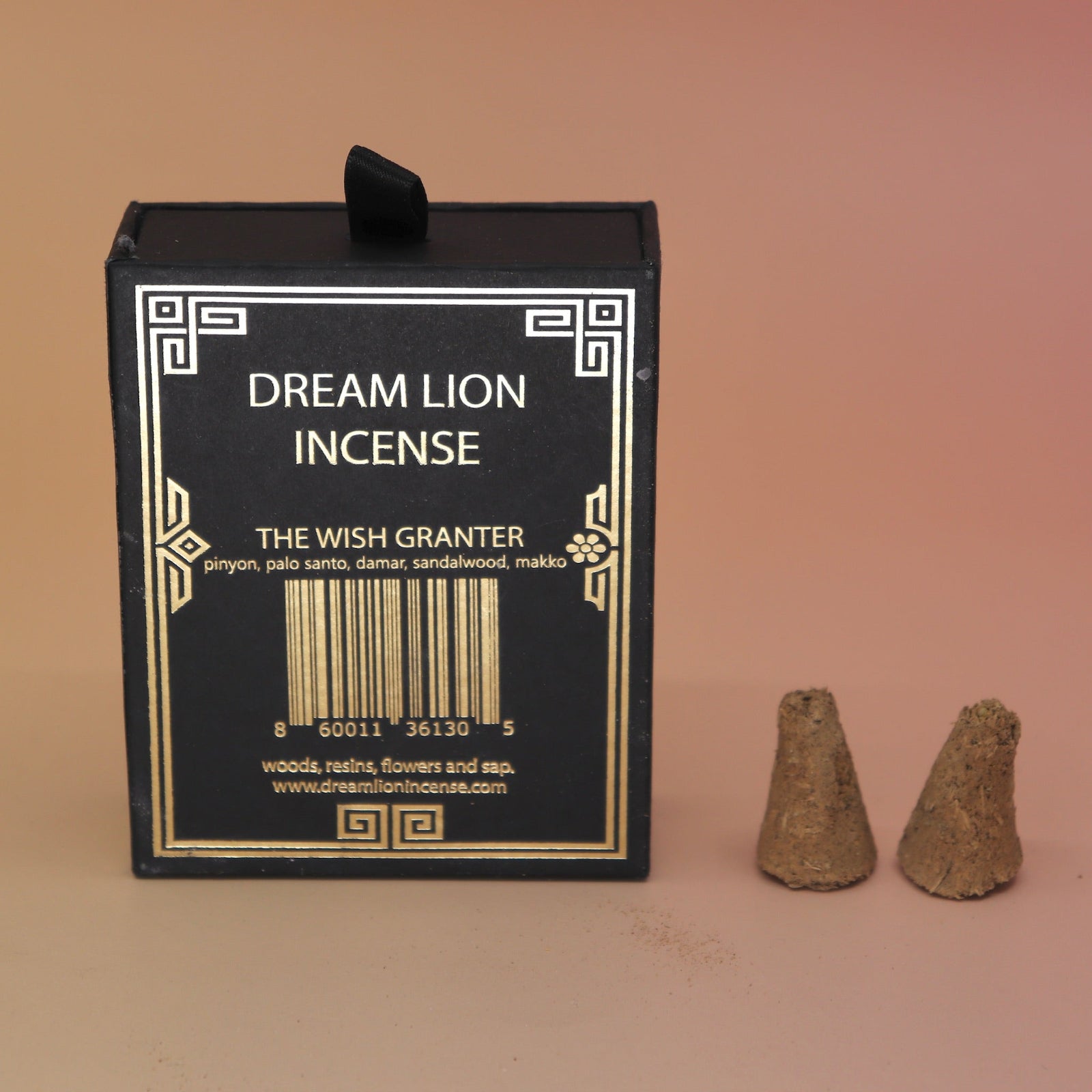 The back of the Wish Granter Incense Cones box next to two incense cones on a pink and yellow background.
