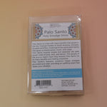 The back of the Holy Smudge Sticks - Pack of 6 4" Palo Santo Sticks on a pink and yellow background.