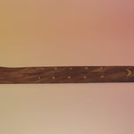 The Moon Wooden Incense Burner on a pink and yellow background.