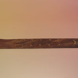 The Moon Wooden Incense Burner on a pink and yellow background.