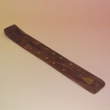 The Buddha Wooden Incense Burner on a pink and yellow background.