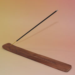 The Plain Wooden Incense Burner with an incense stick on a pink and yellow background.