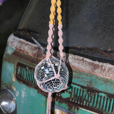 Someone holding the blush and mustard Color Dip Disco Ball Hanger - Macrame Plant Hanger in front of a vintage teal Volkswagen bus.