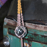 Someone holding the blush and mustard Color Dip Disco Ball Hanger - Macrame Plant Hanger in front of a vintage teal Volkswagen bus.