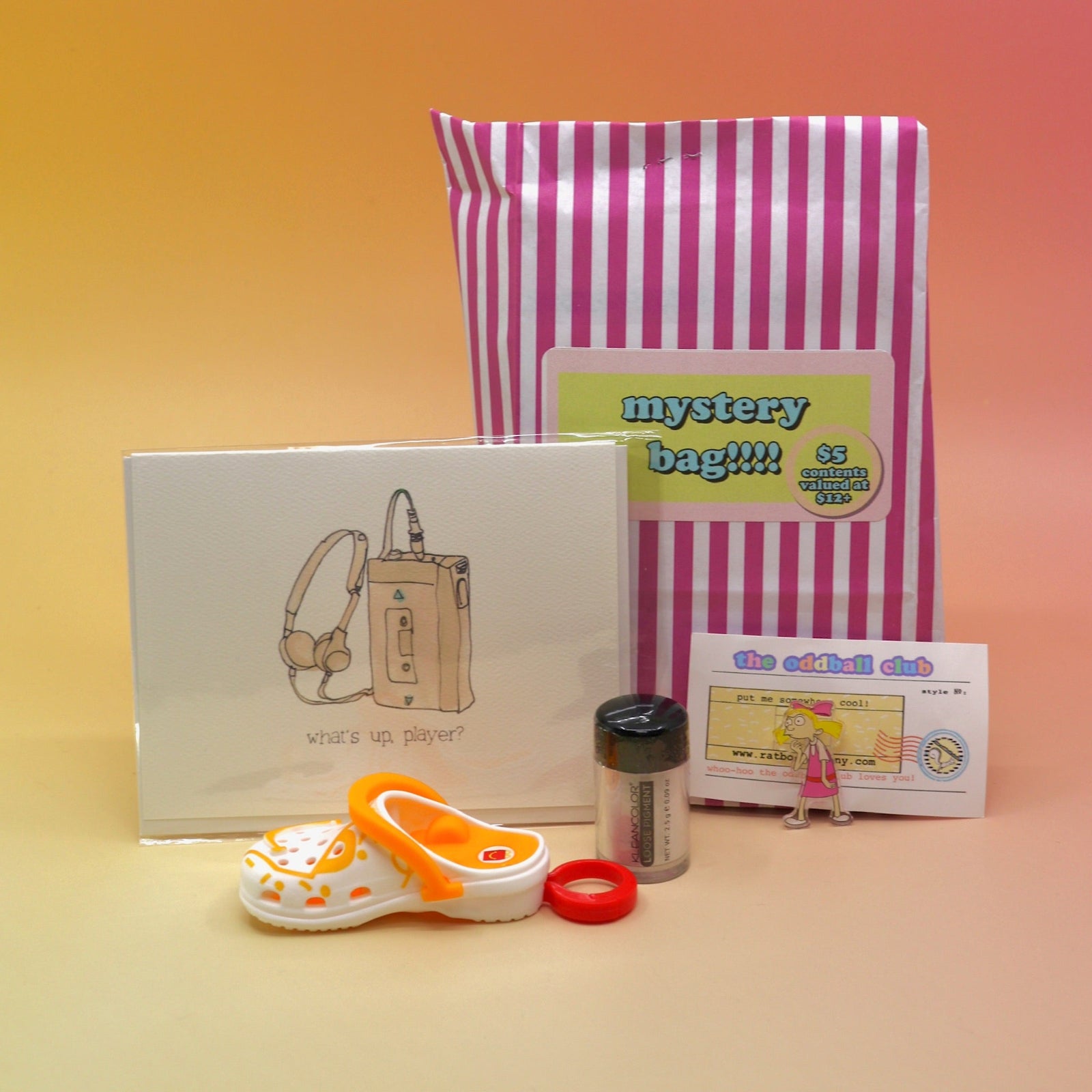 The 5 Dollar Blind Mystery Bag with its contents out on a pink and orange background.