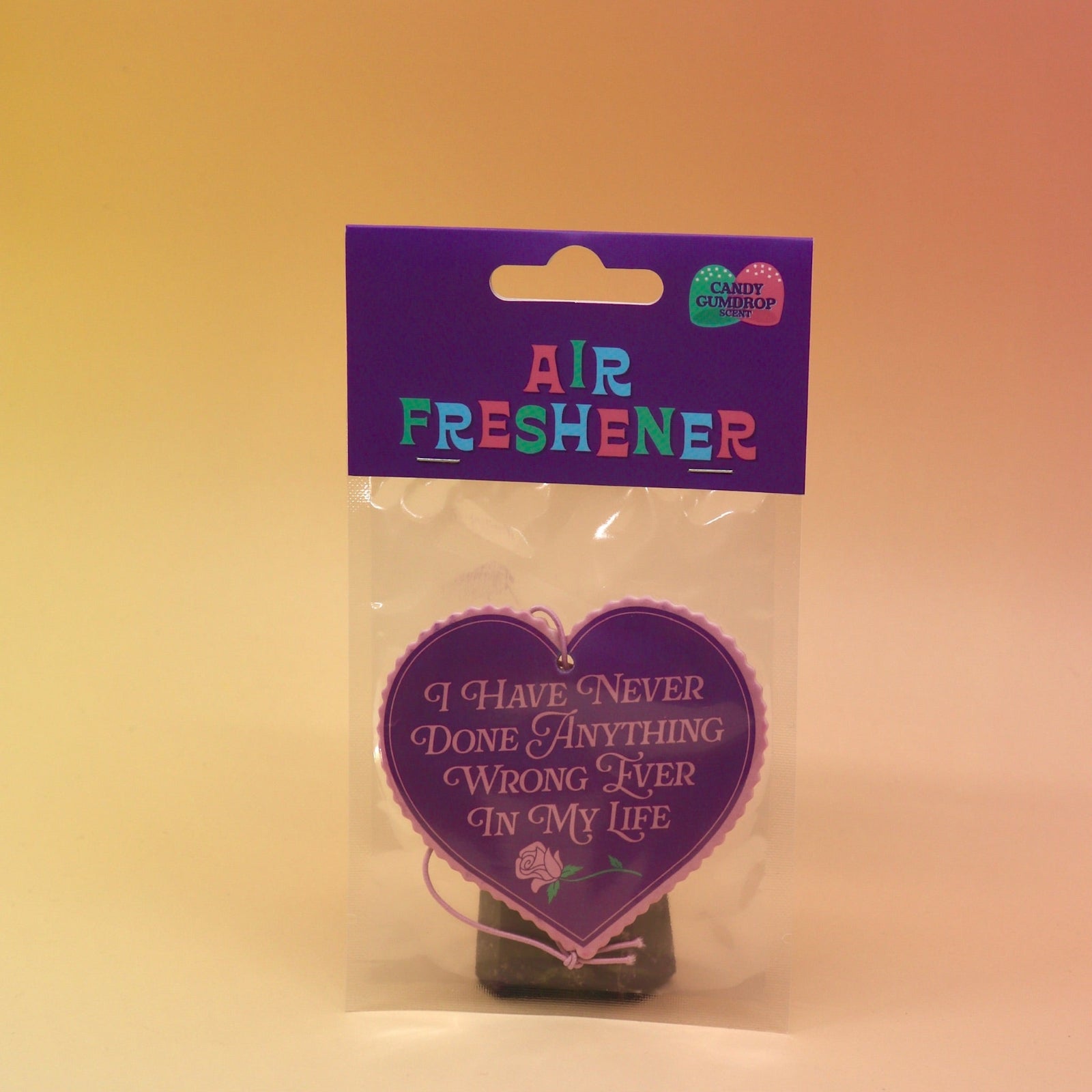 The I Have Never Done Anything Wrong - Candy Scented Air Freshener on a pink and yellow background.