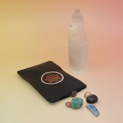 The Mystery Crystal Grab Bag - 5 Count on a pink and yellow background with its contents out of the bag.