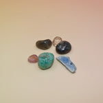 The contents of the Mystery Crystal Grab Bag - 5 Count on a pink and yellow background.
