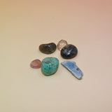 The contents of the Mystery Crystal Grab Bag - 5 Count on a pink and yellow background.