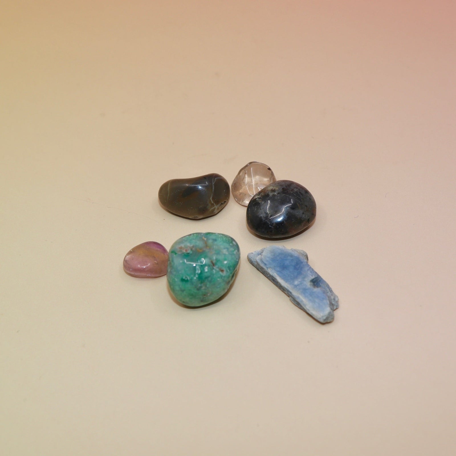 The contents of the Mystery Crystal Grab Bag - 5 Count on a pink and yellow background.