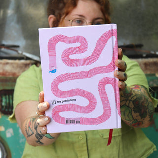 A woman holding The Unfortunate Life of Worms Hardcover Book.