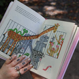 Someone showing one of the pages of the Unfortunate Life of Worms Hardcover Book.
