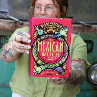 A woman holding the Mexican Witch Lifestyle Hardcover Book.