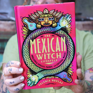 A woman holding the Mexican Witch Lifestyle Hardcover Book.