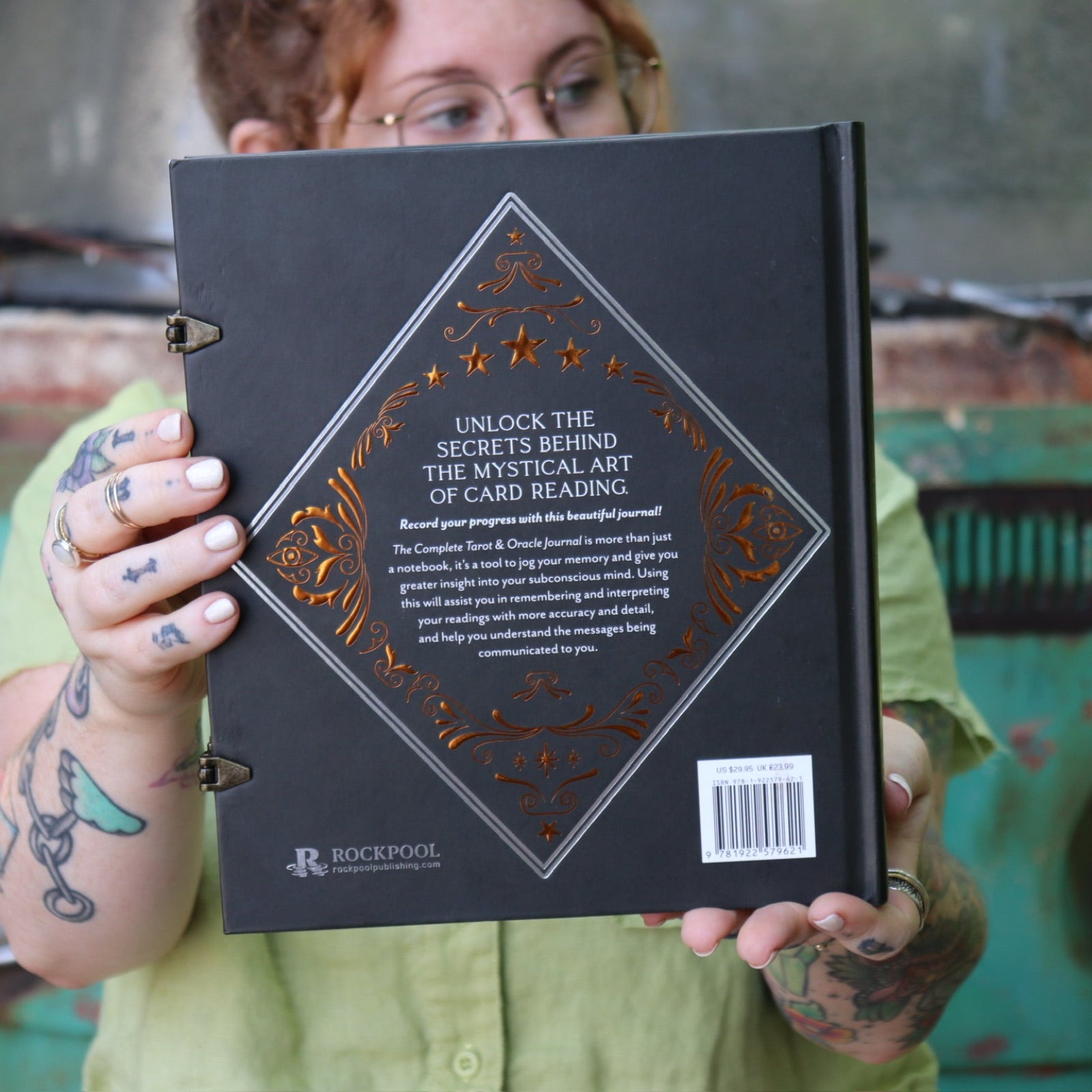 A woman holding the Complete Tarot & Oracle Journal Hardcover Book.