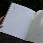 A woman holding the Complete Tarot & Oracle Journal Hardcover Book open to show off the pages.