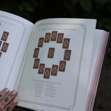 A woman holding the Complete Tarot & Oracle Journal Hardcover Book open to show off the pages.