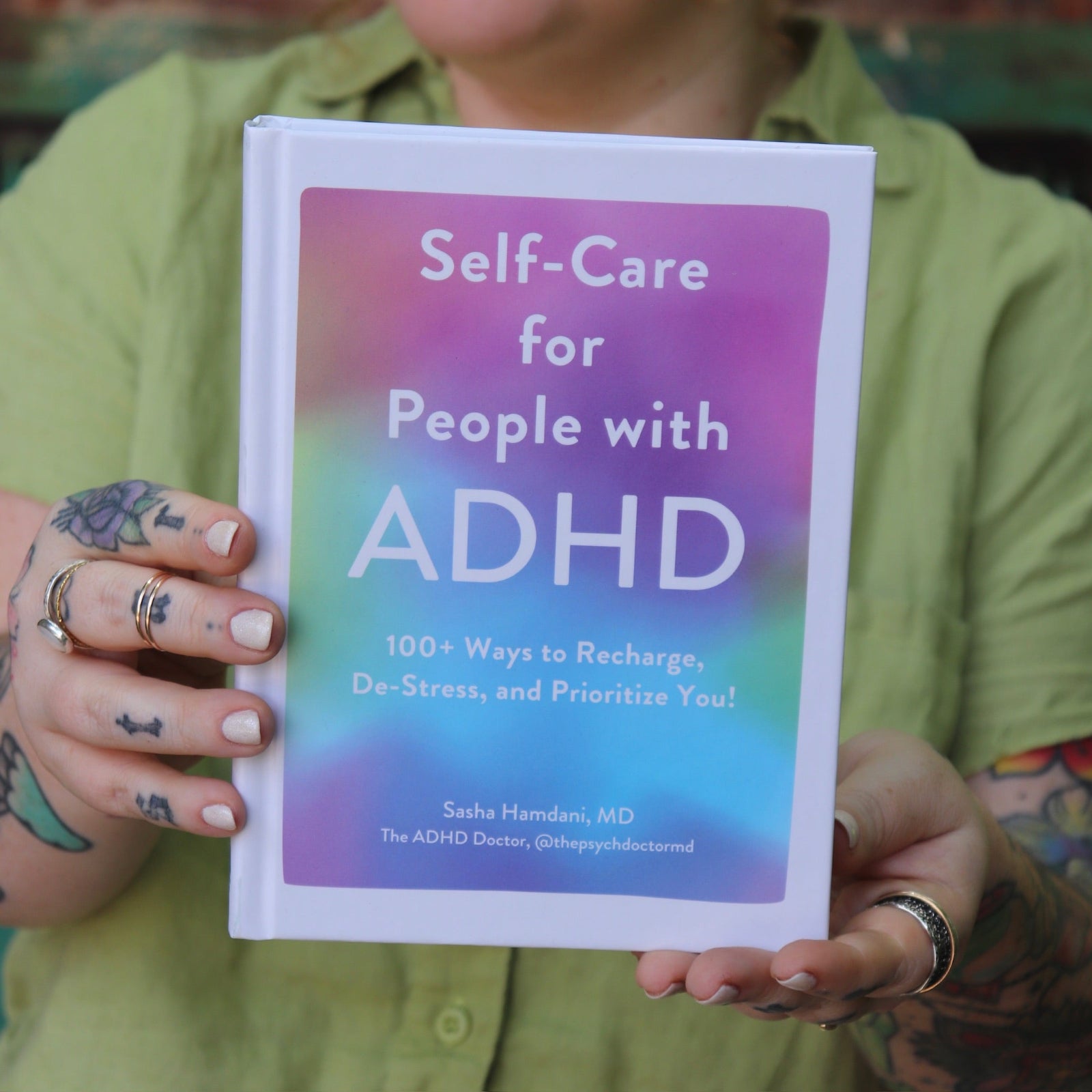 A woman holding the Self-Care for People with ADHD Hardcover Book.