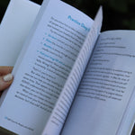 A woman holding the Self-Care for People with ADHD Hardcover Book open to show off its pages.