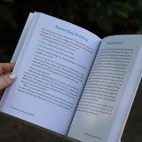 A woman holding the Self-Care for People with ADHD Hardcover Book open to show off its pages.