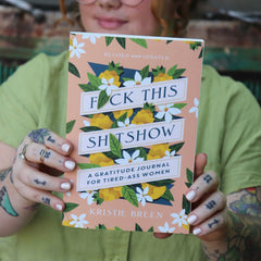 Someone holding the F*ck This Sh*tshow Gratitude Journal.