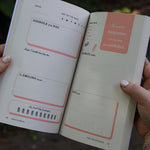 Someone holding the F*ck This Sh*tshow Gratitude Journal open to show off the pages.