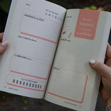 Someone holding the F*ck This Sh*tshow Gratitude Journal open to show off the pages.