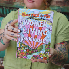 A woman holding the Women Living Deliciously Hardcover Book.