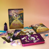 The contents of the Seasons of the Witch - Litha Oracle Card Deck with crystals around them.
