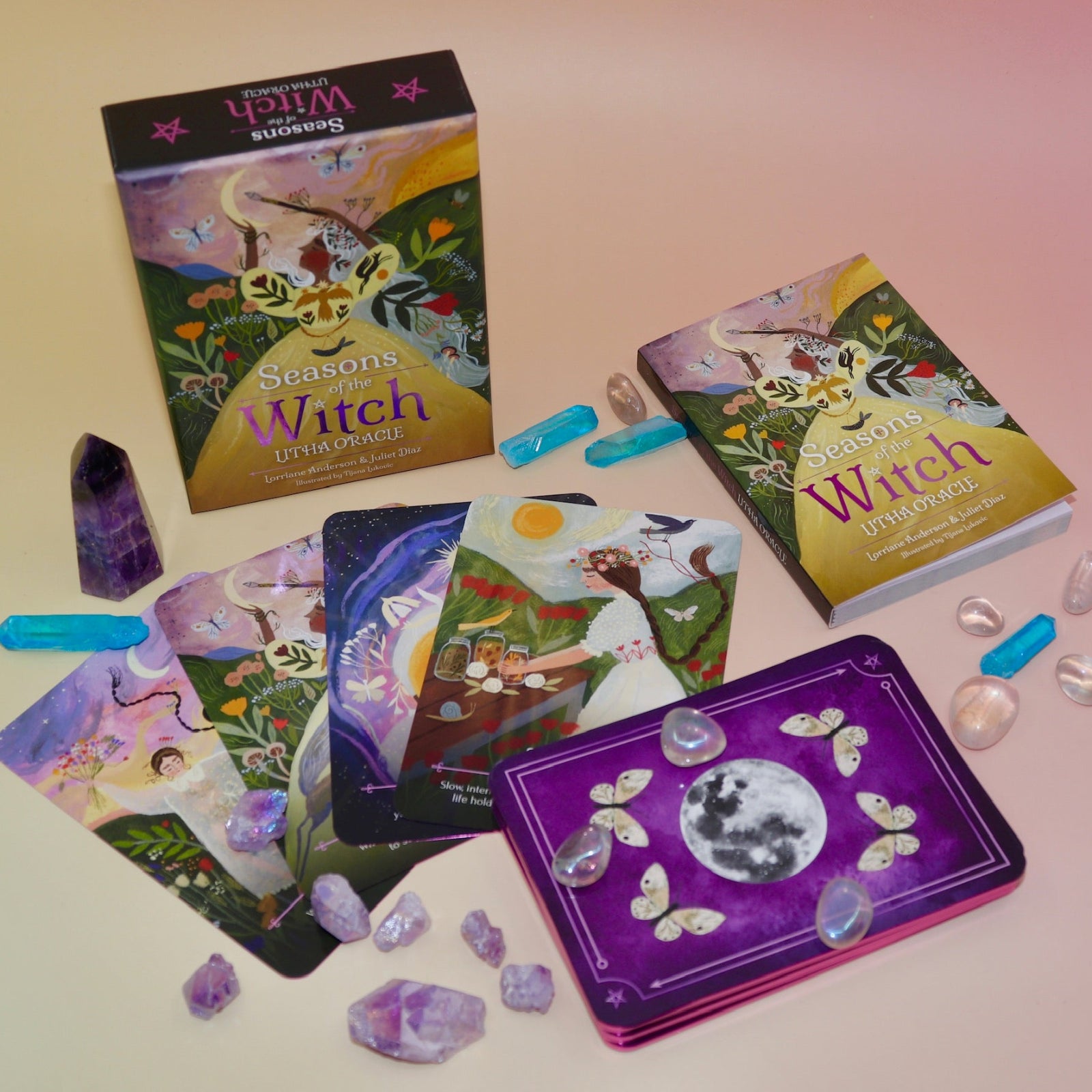 The contents of the Seasons of the Witch - Litha Oracle Card Deck with crystals around them.