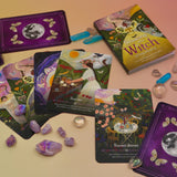 The contents of the Seasons of the Witch - Litha Oracle Card Deck with crystals around them.