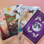 Someone holding four cards from the Seasons of the Witch - Litha Oracle Card Deck.