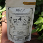 The back of the Calm + Stress Relief Tonic Tea on a rusty red surface next to ivy.