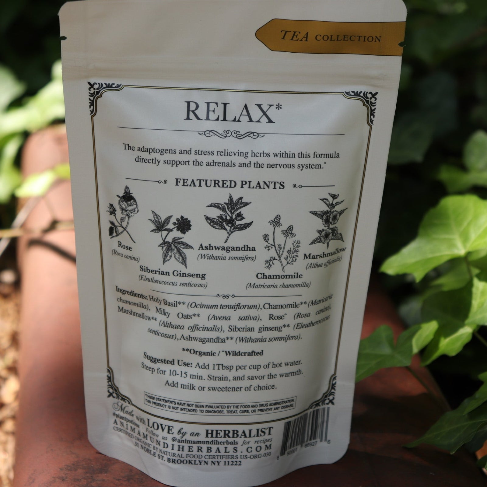 The back of the Calm + Stress Relief Tonic Tea on a rusty red surface next to ivy.