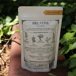 The back of the Breathe - Organic Lung Tonic Tea on a rusty red surface next to ivy.