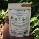 The back of  the Womb Tea - Nourish + Empower Tonic Tea red surface next to ivy.