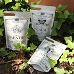 The Womb, Breather, and Calm Tea all on a surface with ivy.