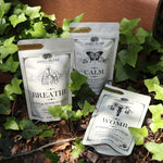 The Womb, Breather, and Calm Tea all on a surface with ivy.